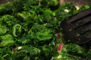 Spinaci freschi in una ciotola, pronti per essere cucinati, evidenziando il rischio di perdita di ferro.