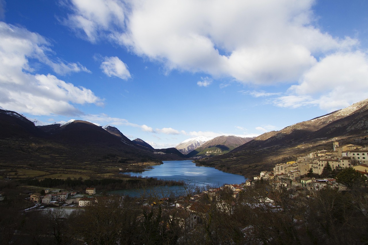 Vista del lago di Tenno con acque turchesi e il borgo medievale sullo sfondo.