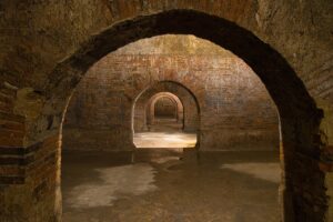 Vista panoramica della città sotterranea di Napoli, con cavità antiche e affreschi storici.