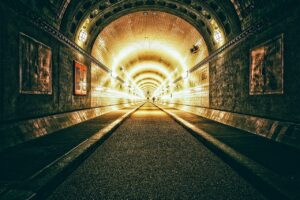 Labirinto sotterraneo misterioso con tunnel e archi, immerso nell'oscurità e nell'atmosfera enigmatica.